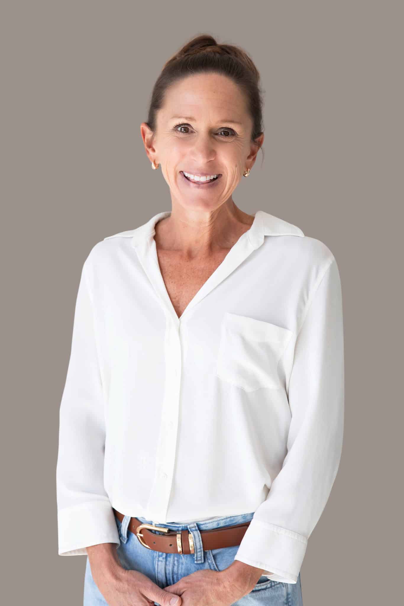 Kaitlin McMillan smiling in white blouse against neutral background.