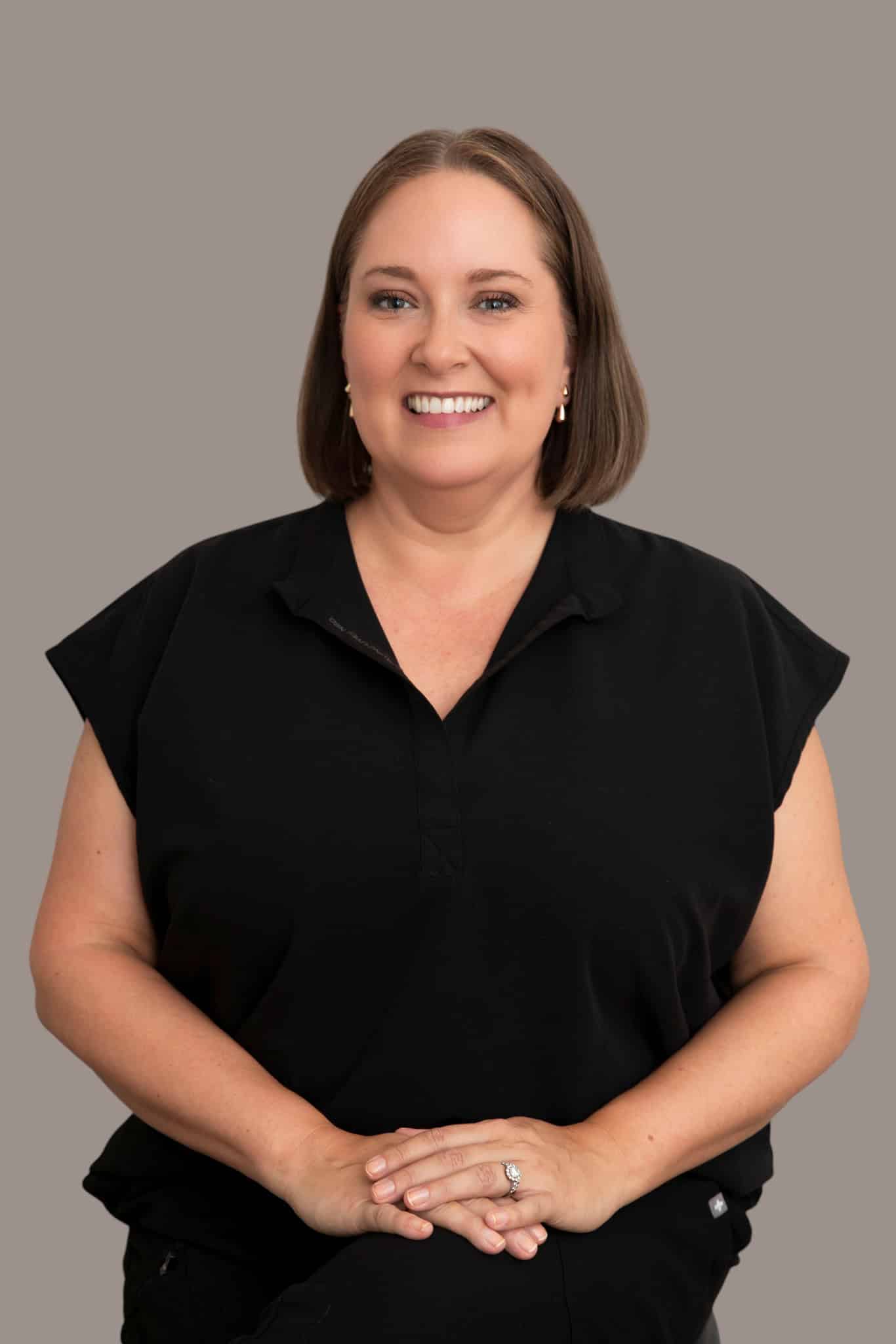 Kaitlin McMillan smiling portrait in black top.