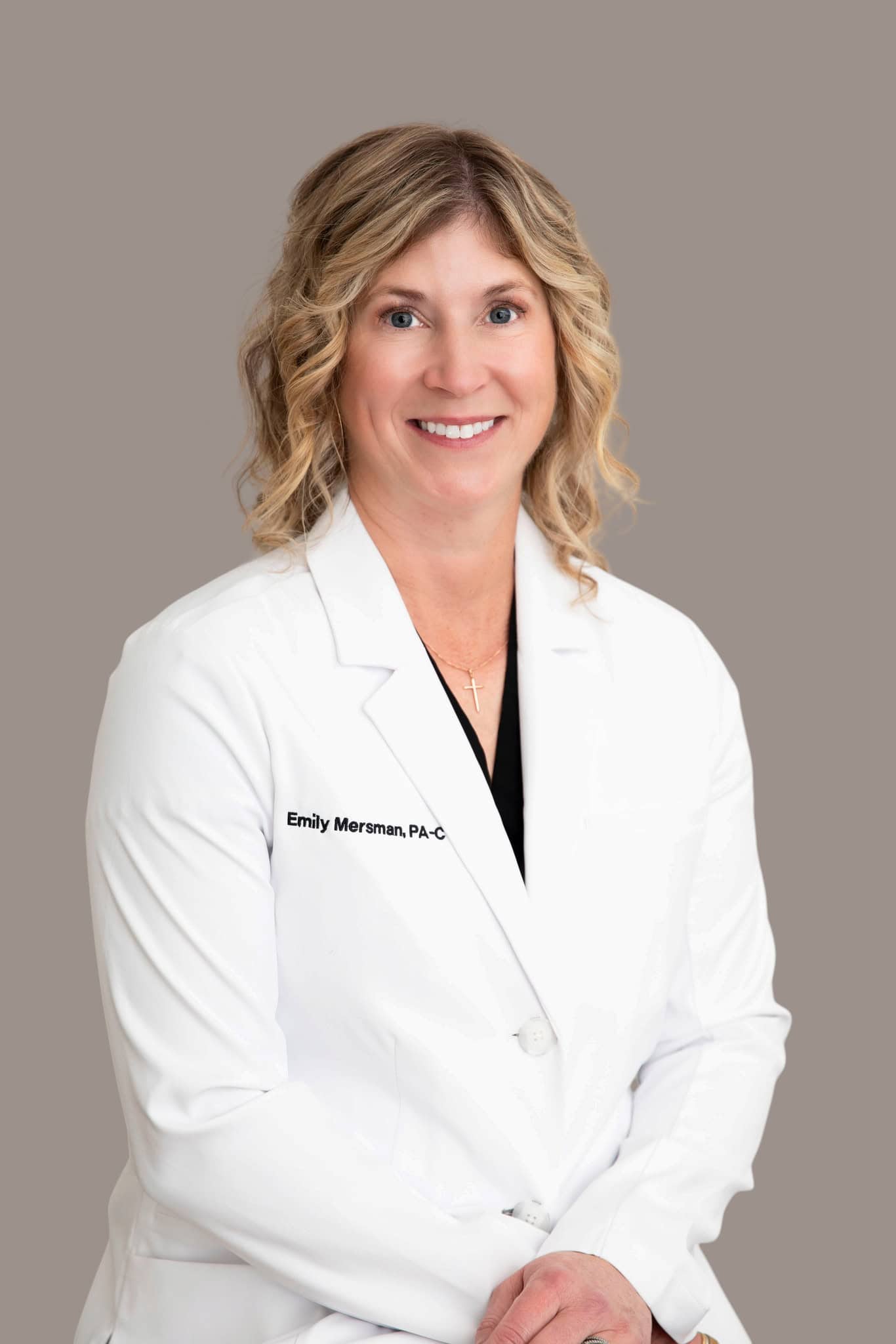 Portrait of Kaitlin McMillan in a white medical coat, friendly and professional.